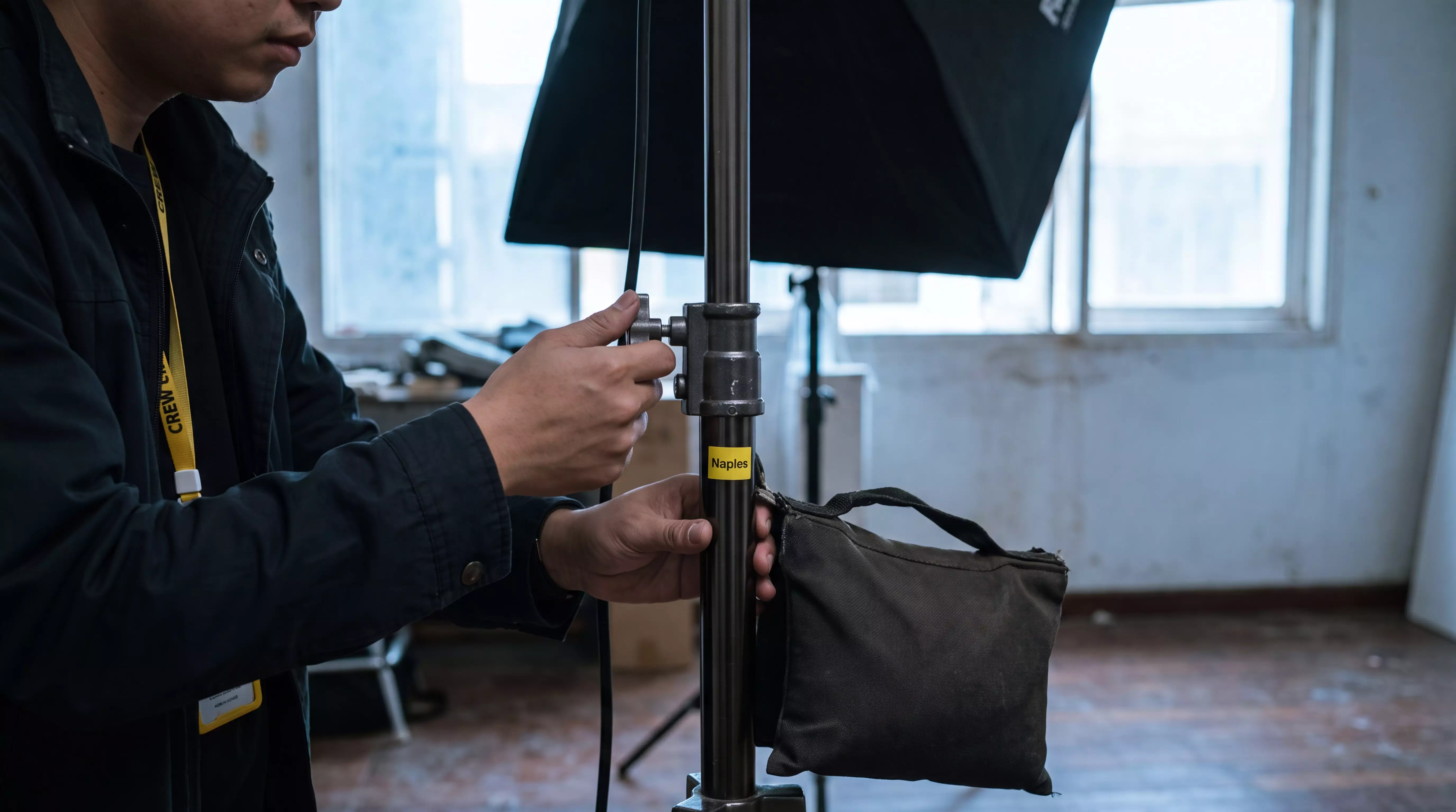 Hands adjusting a light stand knob